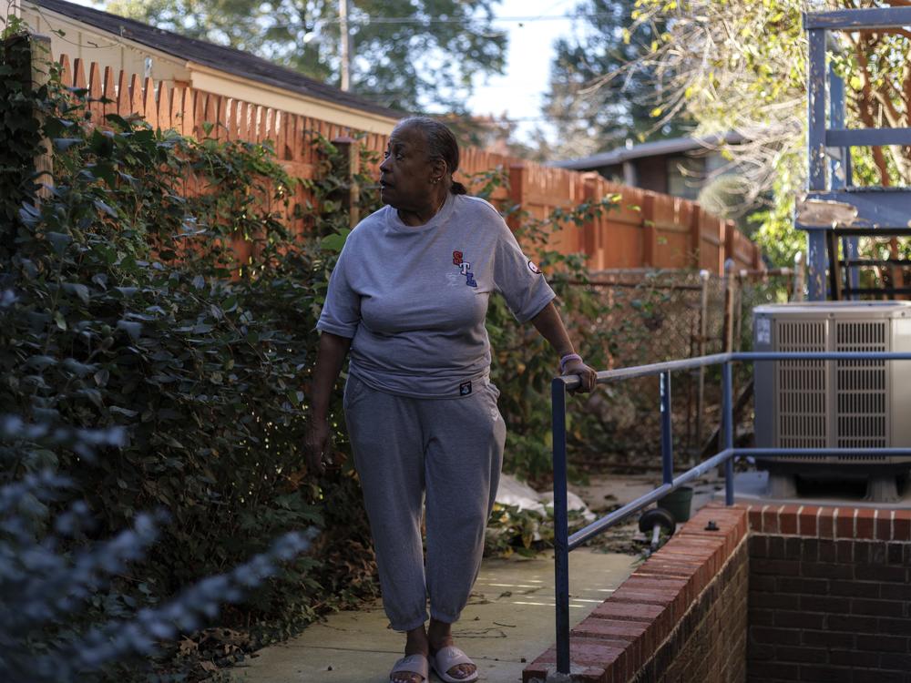 Pat Haskins, a 72-year-old retired school teacher, poses for a portrait in the backyard of her home in Silver Spring, Md., on Oct. 22.  She had struggled to keep up with repairs as her basement flooded, a bathroom floor sagged and her disabled partner needed a ramp.