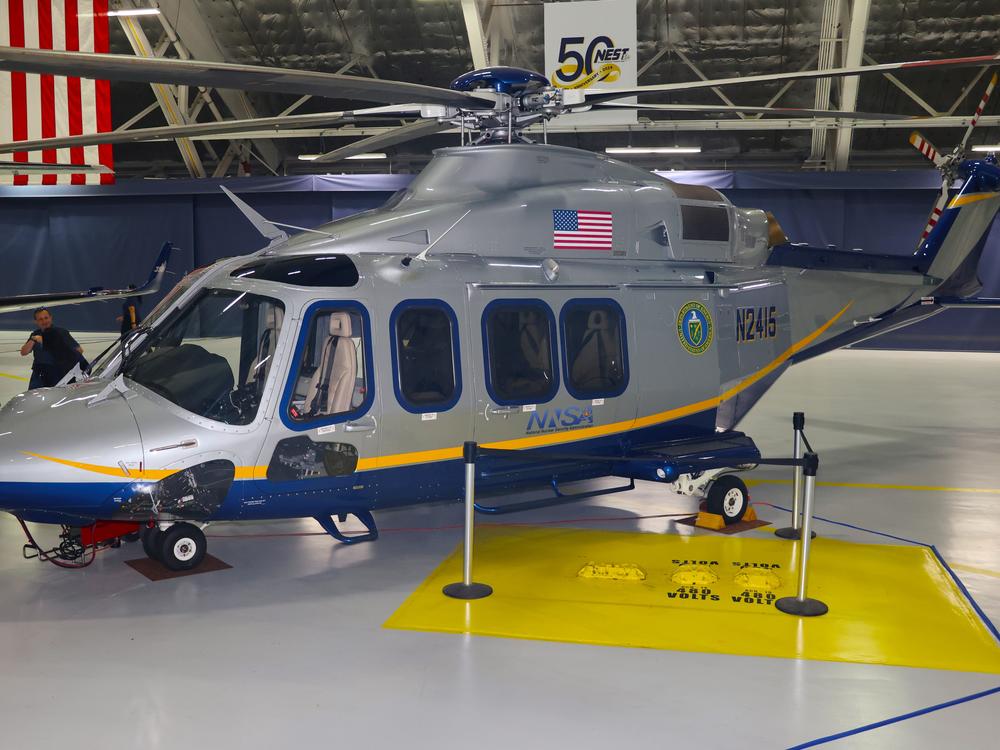 A NEST AgustaWestland 139 helicopter equipped with special radiation monitoring equipment on display during the team's 50th anniversary celebration at Joint Base Andrews. The helicopters, which measure radiation by flying low and slowly,  are deliberately painted with a civilian color scheme to avoid the 