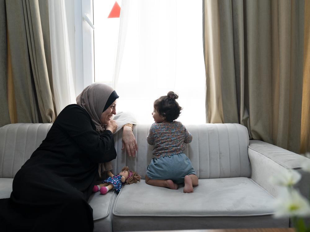 Soha Sakallah plays with her granddaughter, Mariam, at an apartment complex for refugees from Gaza in Doha, Qatar, in September soon after they arrived to the country from Egypt.