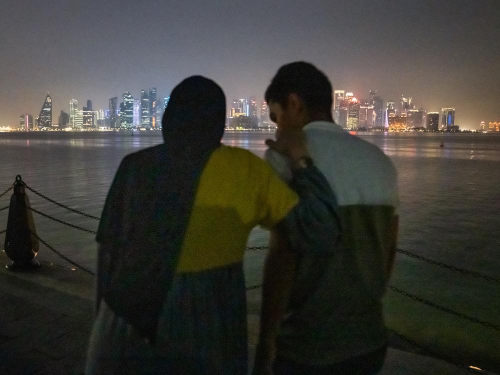 Raneem Hijazi walks a few steps with help from her husband, Asaad Sakallah, to see the skyline of Doha from the port. They take some photos in the city and later get ice cream, building new memories together in this new life.