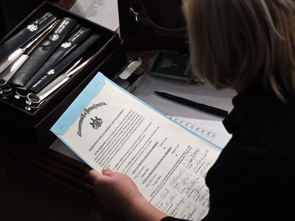 A person holds the certificate of electoral votes from Pennsylvania during a joint session of Congress early on Jan. 7, 2021, as the counting of electoral votes resumed after the riot at the U.S. Capitol.