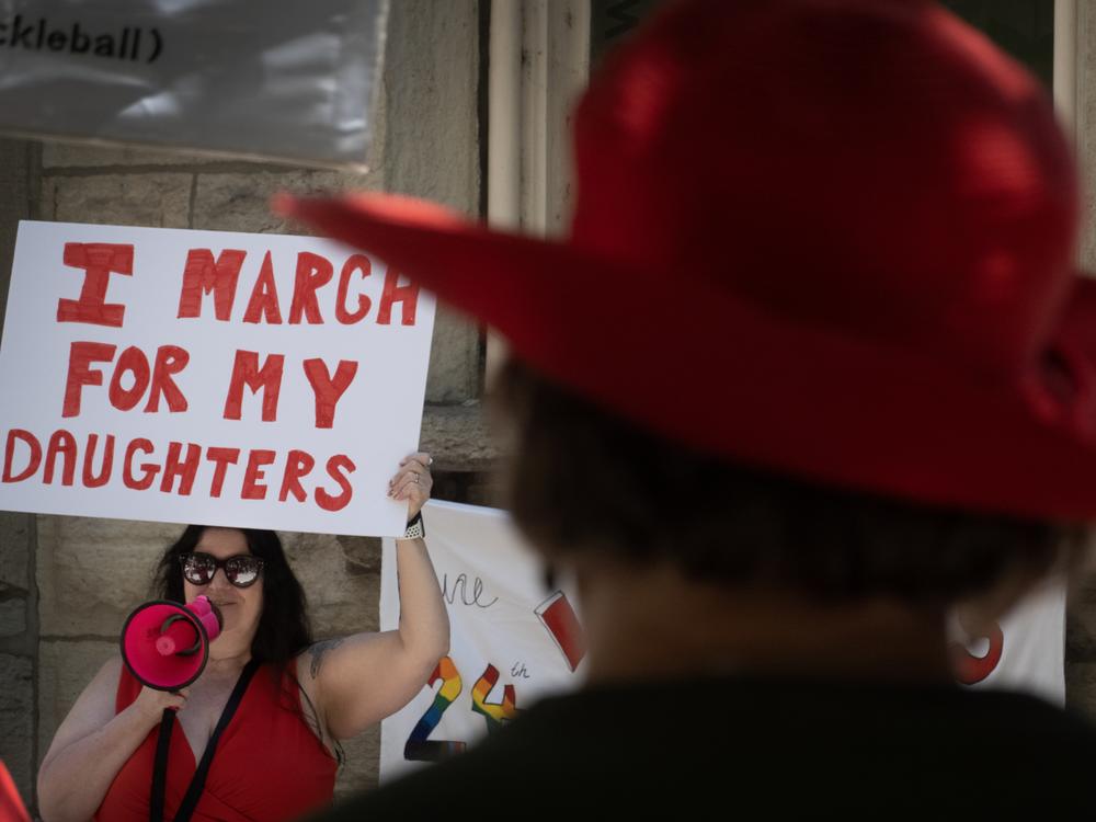 People gather at a women's rights march in Chicago on the second anniversary of the <em>Dobbs</em> decision, the Supreme Court ruling that overturned <em>Roe v. Wade</em> and struck down federal abortion protections.