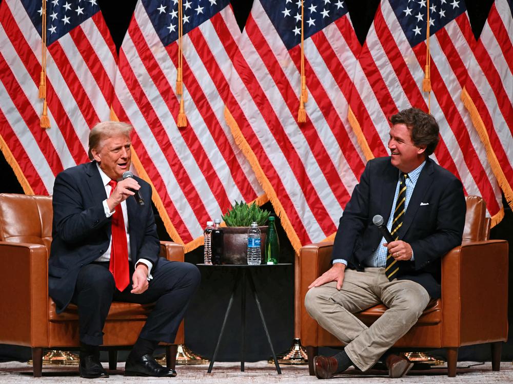 Former President Donald Trump speaks with conservative commentator Tucker Carlson in Glendale, Ariz., on Oct. 31, 2024.