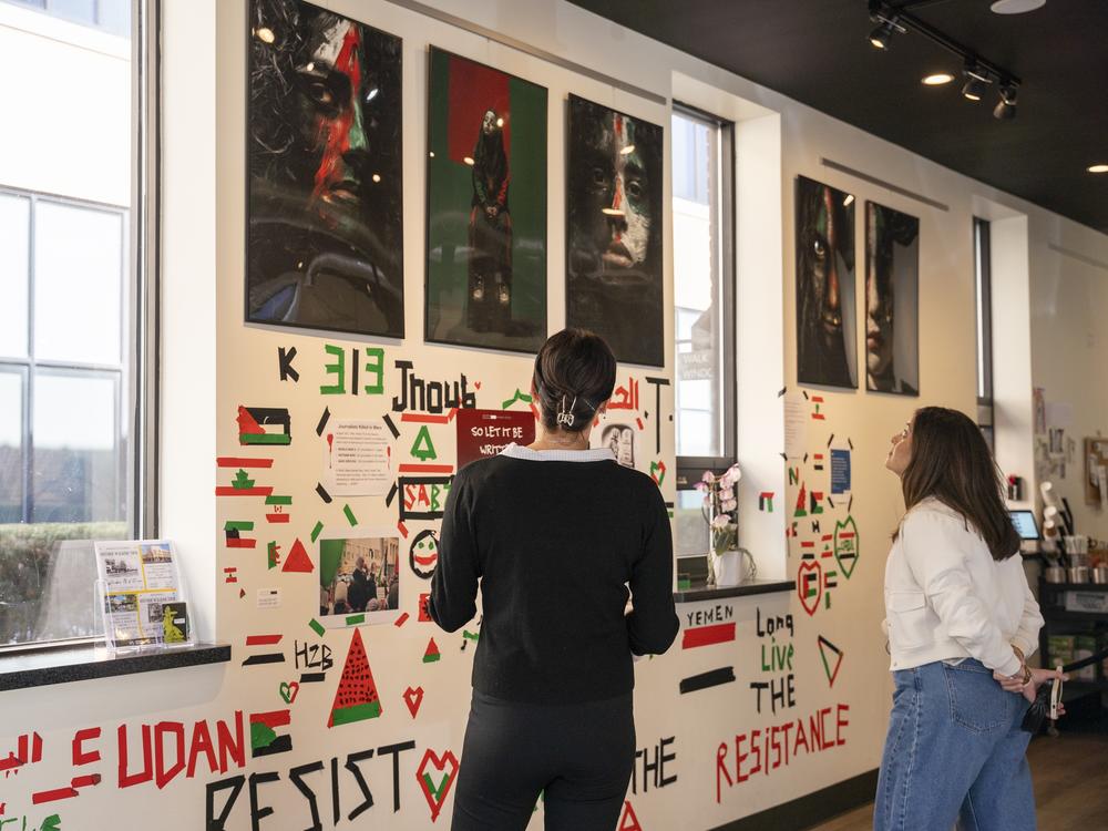 Lisa Alcodray speaks with a customer about the exhibition inside the Black Box cafe on Oct. 10 in Dearborn, Mich.