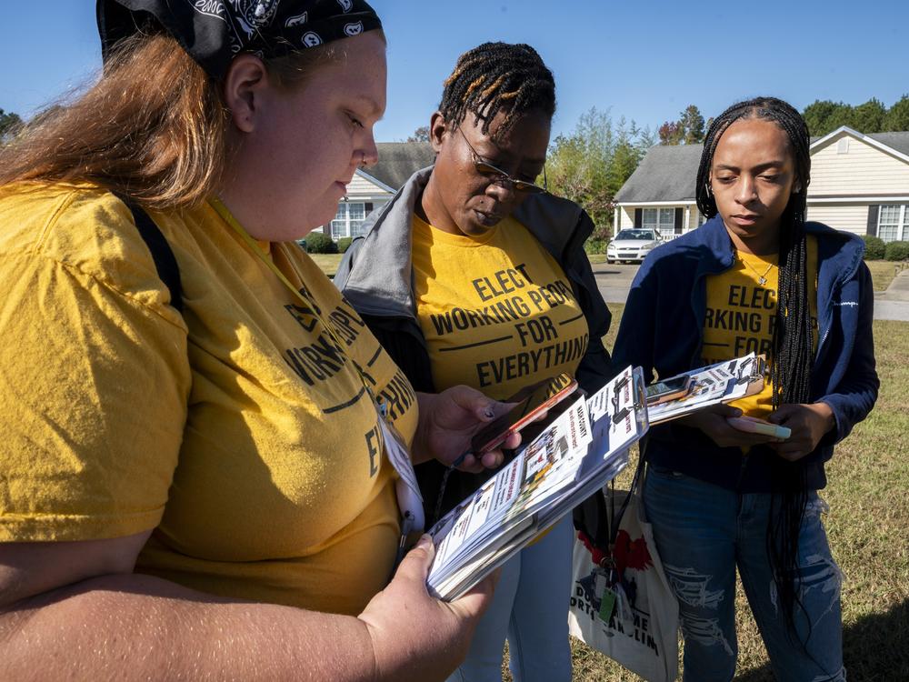 (From left) canvassers Arquette Turnage, Andrea Farmer and Tynia Anstead check their list of potential voters.