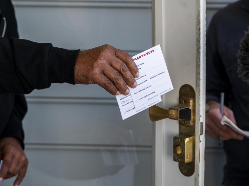 Down Home North Carolina canvassers pass out cards with voting information.