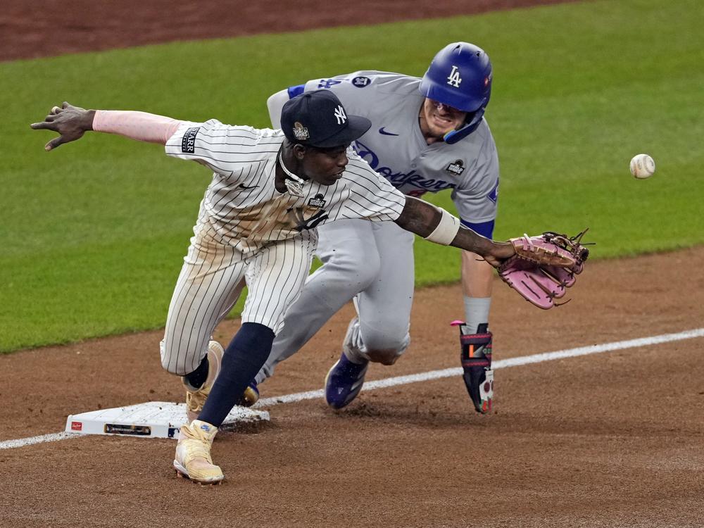 Los Angeles Dodgers' Kiké Hernández, right, is safe at third as New York Yankees third baseman Jazz Chisholm Jr. reaches for a throw from shortstop Anthony Volpe during the fifth inning in Game 5 of the baseball World Series, Wednesday, Oct. 30, 2024, in New York. Volpe was charged with a throwing error.