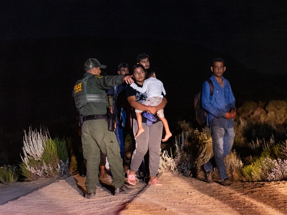 Migrants queue up to be processed by U.S. Border Patrol agents after crossing into the U.S. from Mexico through an abandoned railroad on June 23, 2024 in Jacumba Hot Springs, San Diego, California.