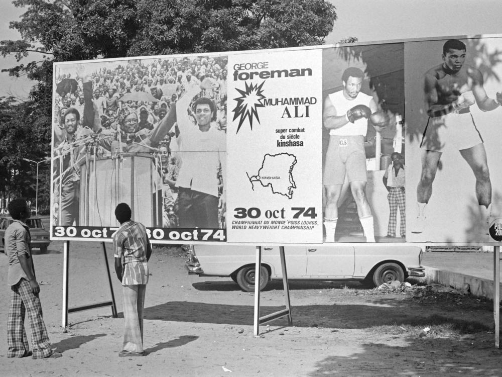 People look at a billboard in Kinshasa on Oct. 30, 1974, announcing the fight between U.S. boxers Muhammad Ali and George Foreman. That day, Ali knocked out Foreman in a clash of titans known as the 