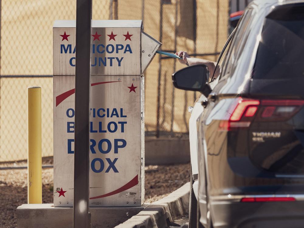 A voter drops a ballot into the ballot drop box at the Maricopa County Tabulation and Election Center in Phoenix, Arizona, on October 23, 2024. With both parties telling their supporters to vote early, concerns about ballot drop boxes are resurfacing.