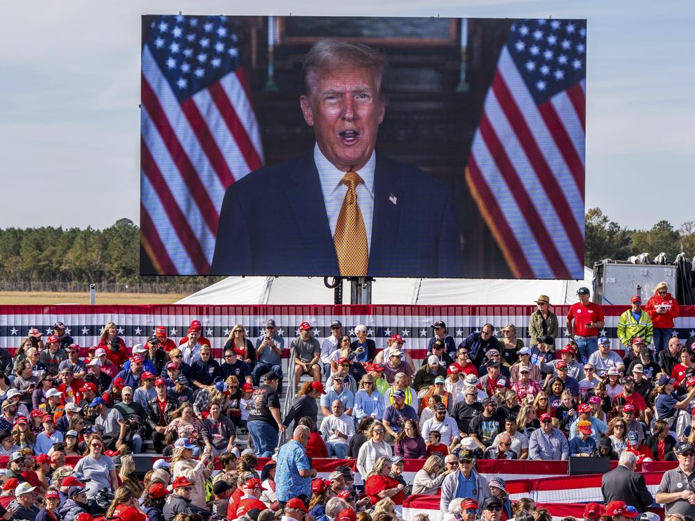 A video plays as supporters arrives to hear former President Donald Trump speak at a campaign rally at Kinston Jet Center on Nov. 3, 2024, in Kinston, N.C.