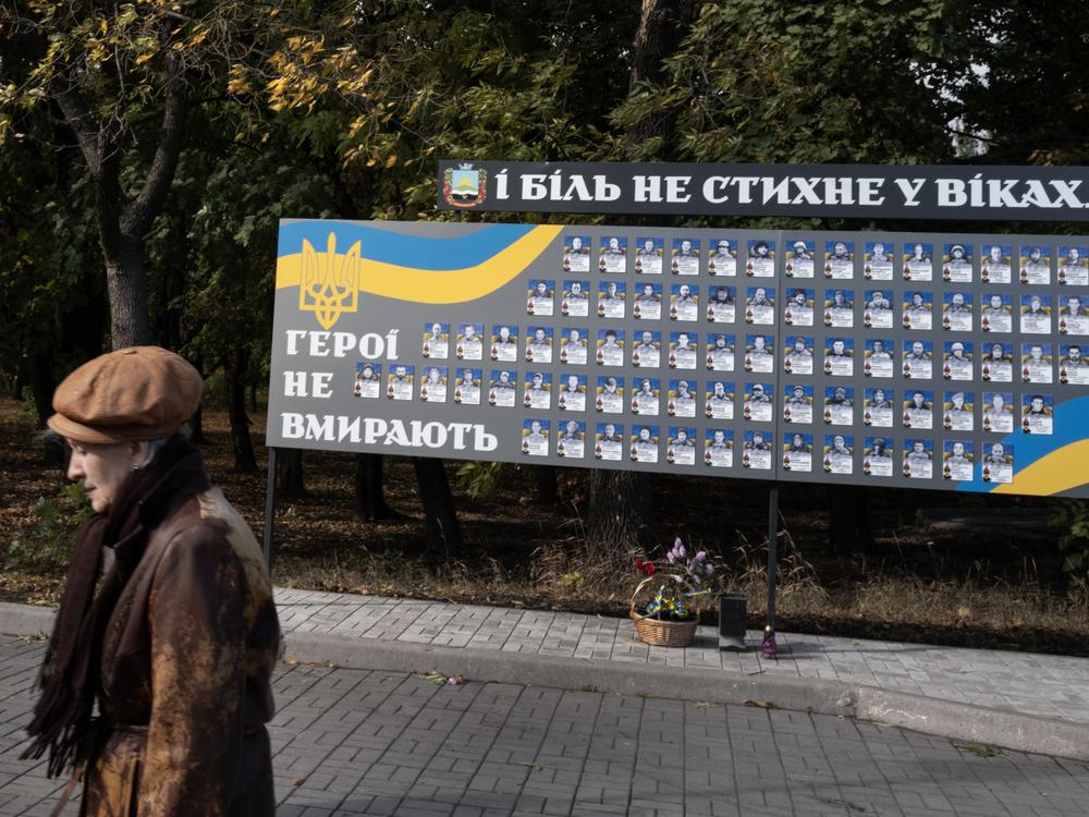 A woman passes a monument to fallen Ukrainian soldiers in Dobropillya, Ukraine, on Oct. 17.