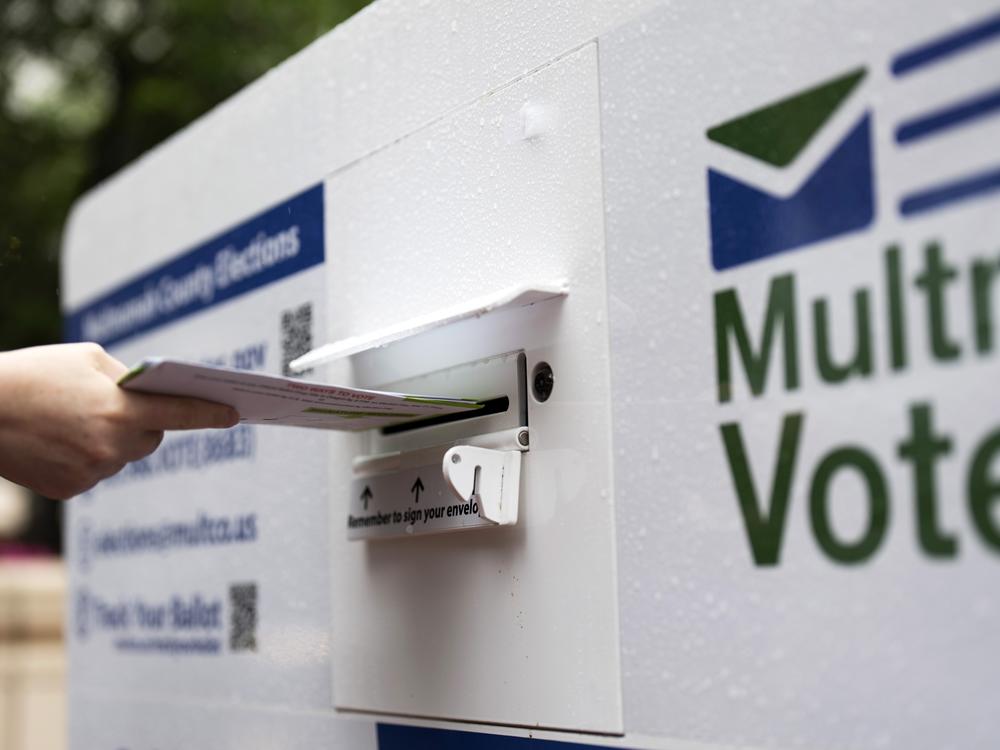 A person drops off a mail ballot at a drop box during primary election voting on May 21 in Portland, Ore.