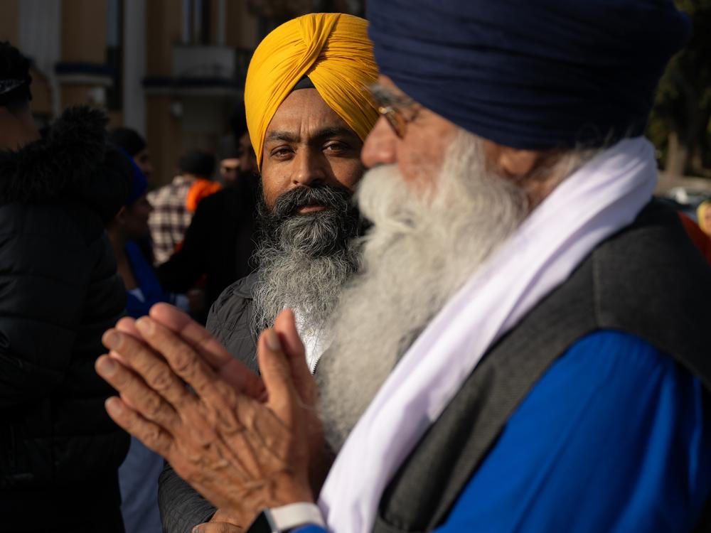 Marchers Amarjit Singh, center, and Karnail Singh, right, pray at Gurdwara Sahib Sikh Temple before finishing the last three miles of a march Friday to urge protections from transnational repression.