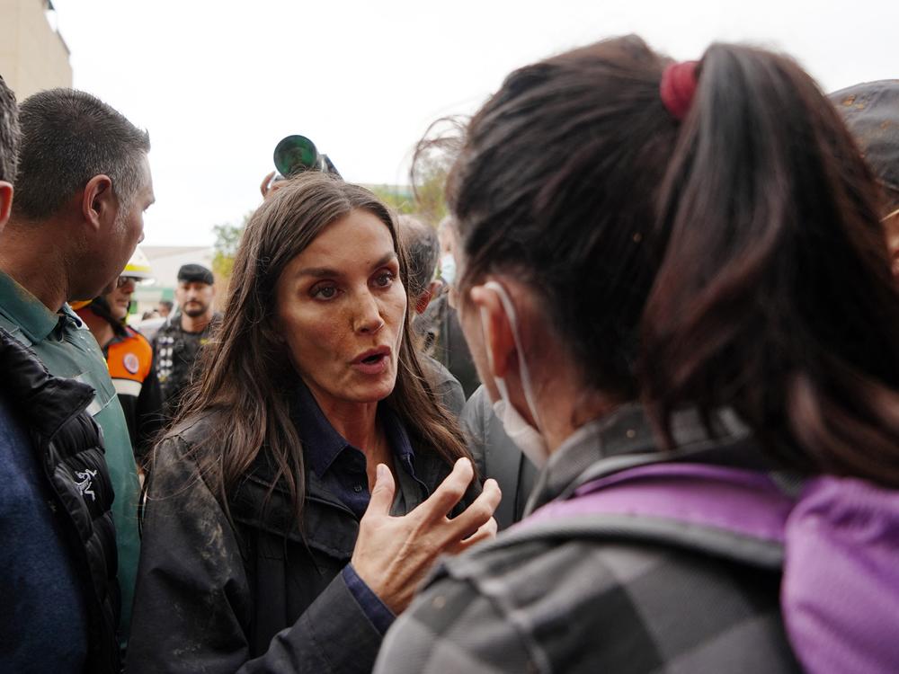 Queen Letizia of Spain talks with a person as angry residents heckled during the Spanish royal couple's visit to Paiporta, in the region of Valencia, eastern Spain, on November 3, 2024, in the aftermath of devastating deadly floods.