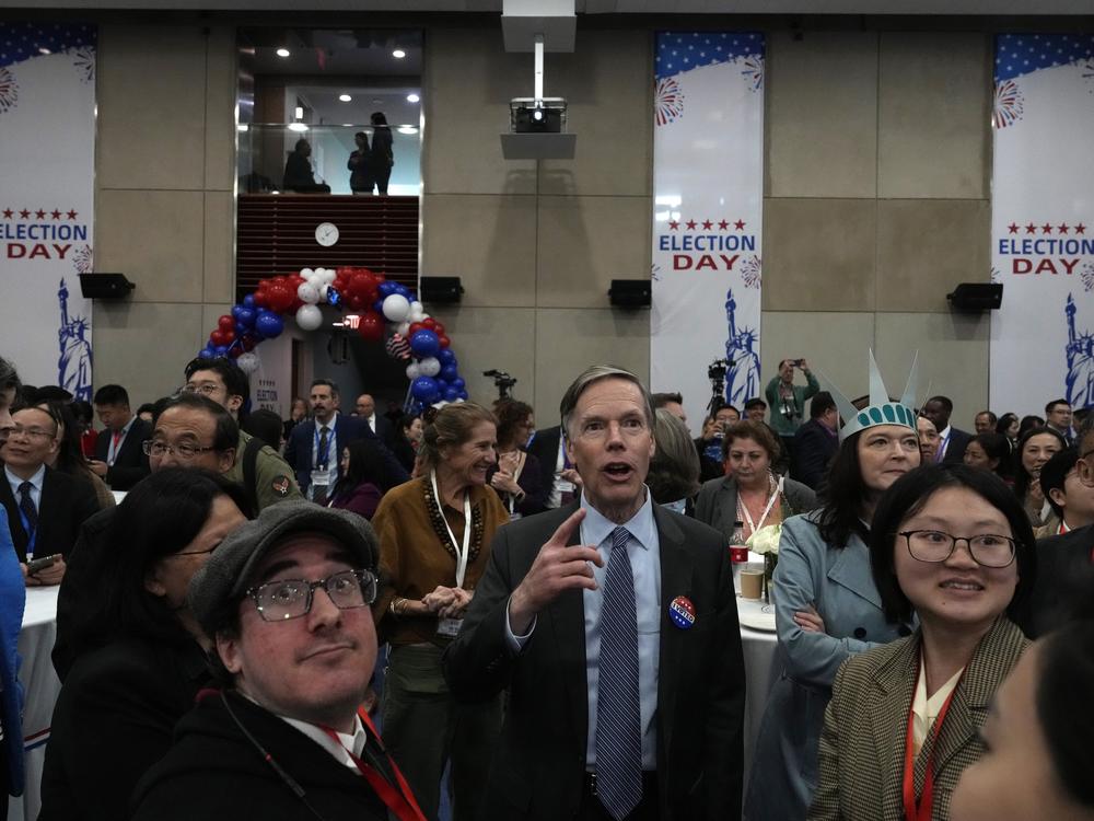 U.S. Ambassador to China Nicholas Burns watches with other attendees as voting results are displayed on screen at a reception at the U.S. Embassy in Beijing on Wednesday.