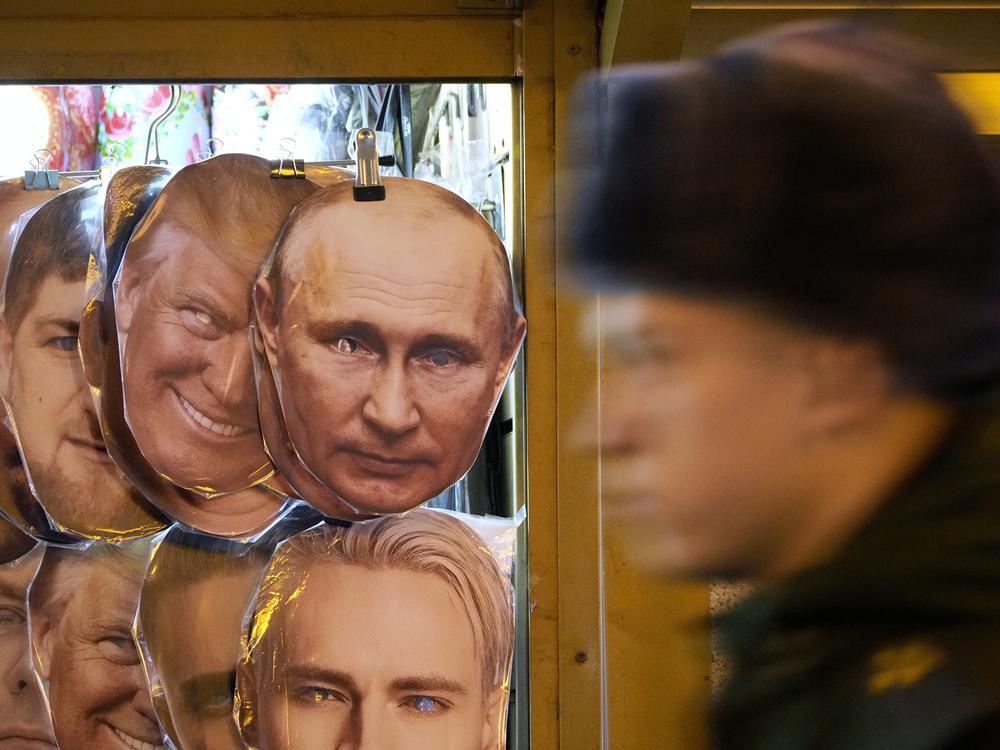 A Russian serviceman walks past face masks depicting Donald Trump and Vladimir Putin for sale at a souvenir shop in St. Petersburg, Russia, on Wednesday.