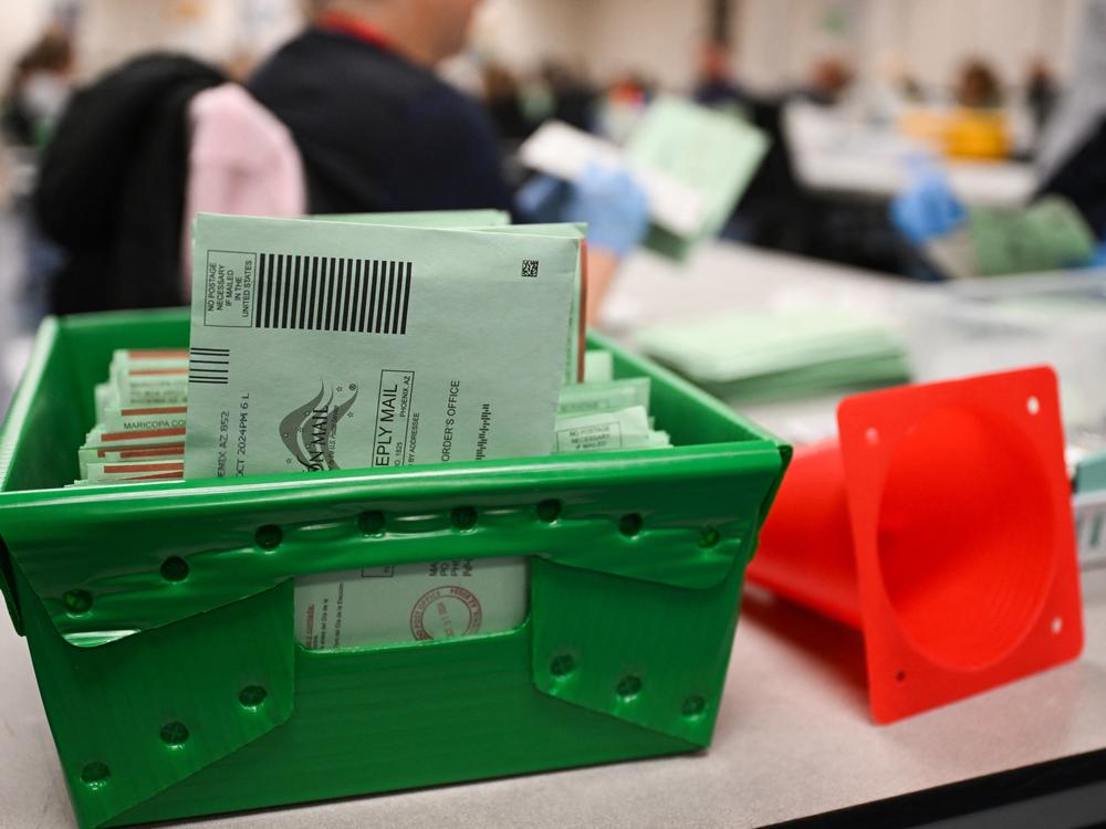 The USPS Election Mail logo is displayed as ballots sit in a tray inside the Maricopa County Tabulation and Election Center (MCTEC) on Election Day, Nov. 5, in Phoenix, Arizona.