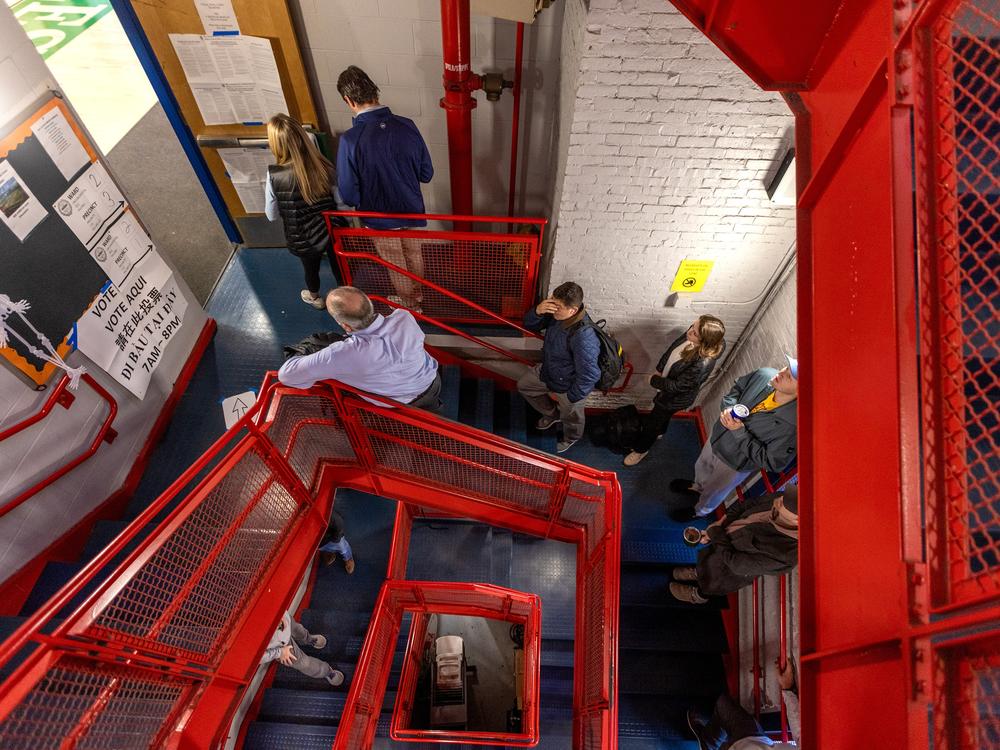 Voters wait in a long line down a spiral staircase before the polls open at 7 a.m. at the Charlestown Boys and Girls Club in Boston, Mass.