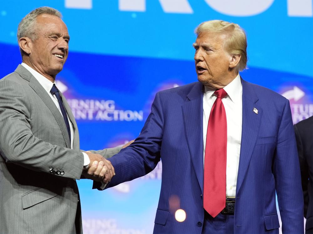 President-elect Donald Trump shakes hands with Robert F. Kennedy Jr., at a campaign rally in October. Kennedy, who is skeptical of vaccines, is among Trump's advisors on health.