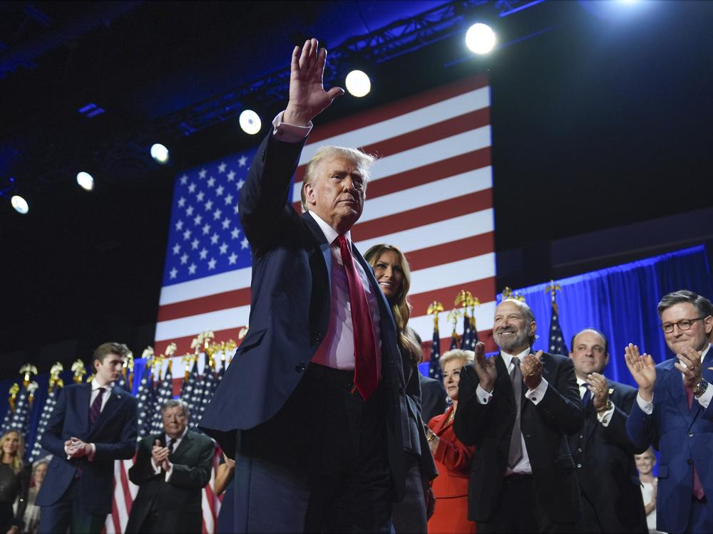 Republican presidential nominee former President Donald Trump waves as he walks with former first lady Melania Trump at an election night watch party at the Palm Beach Convention Center, Wednesday, Nov. 6, 2024, in West Palm Beach, Fla.