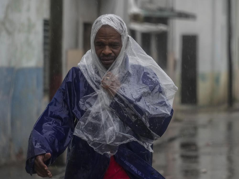A man walks through the wind and rain brought by Hurricane Rafael in Havana, Cuba, Wednesday, Nov. 6, 2024.