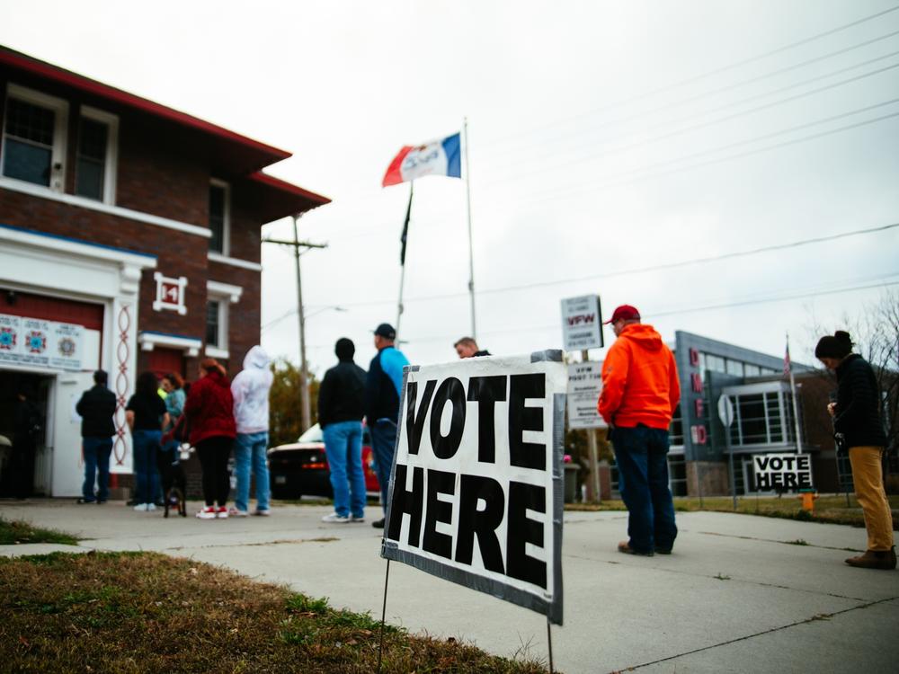 Voters cast their ballot at VFW Post 738 with the state Capitol building in view in Des Moines, Iowa.