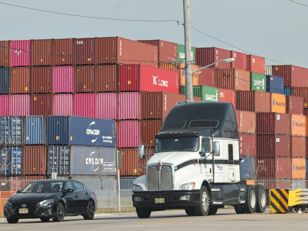 Shipping containers are stacked together at the Port of Newark in Newark, N.J., on Oct. 4. Trump's plans to impose across-the-board tariffs could raise the prices of a lot of goods while risking retaliation from trading partners.
