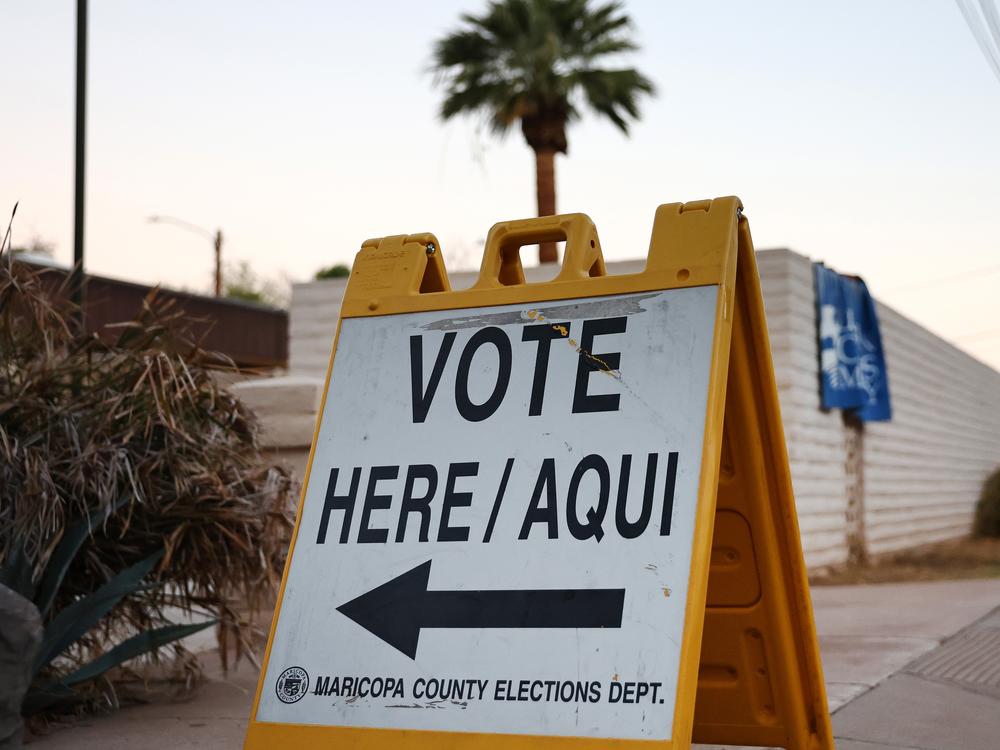 A Vote Here/Aqui sign is posted at a polling place at a church after the polls opened before sunrise on Nov. 05 in Tempe, Arizona.
