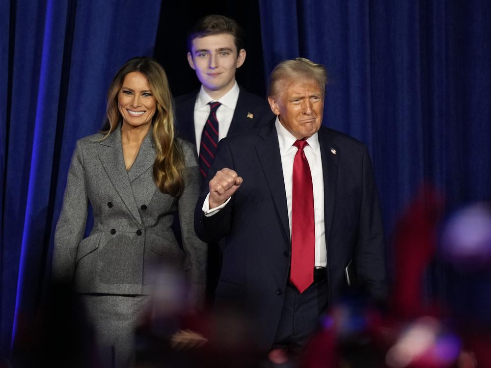 Republican presidential nominee former President Donald Trump, joined by Melania Trump, left, and Barron Trump, arrives to speak at an election night watch party on Nov. 6, 2024, in West Palm Beach, Fla.