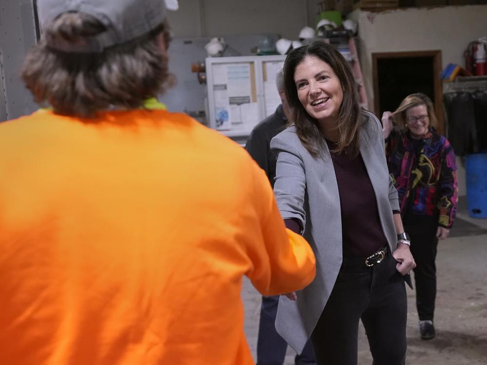 Republican Kelly Ayotte shakes hands with an employee during a visit to a local concrete coating business on Oct. 16 in Manchester, N.H.