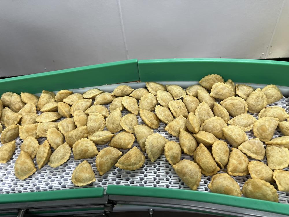 Chicken and vegetable empanadas come out of the fryer and are ready for inspection at the production plant of MasPanadas, a company in Rockville, MD.