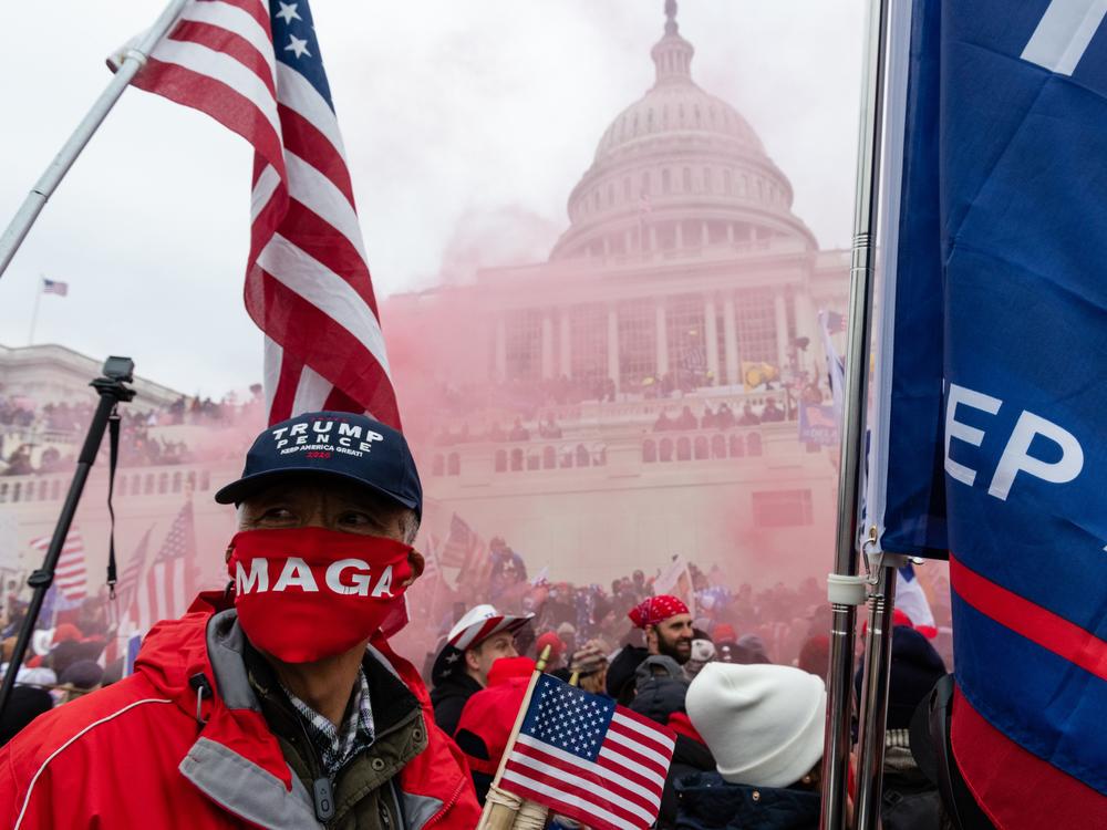 A protester unleashes a smoke grenade in front of the U.S. Capitol building during a protest in Washington, D.C., U.S., on Wednesday, Jan. 6, 2021.