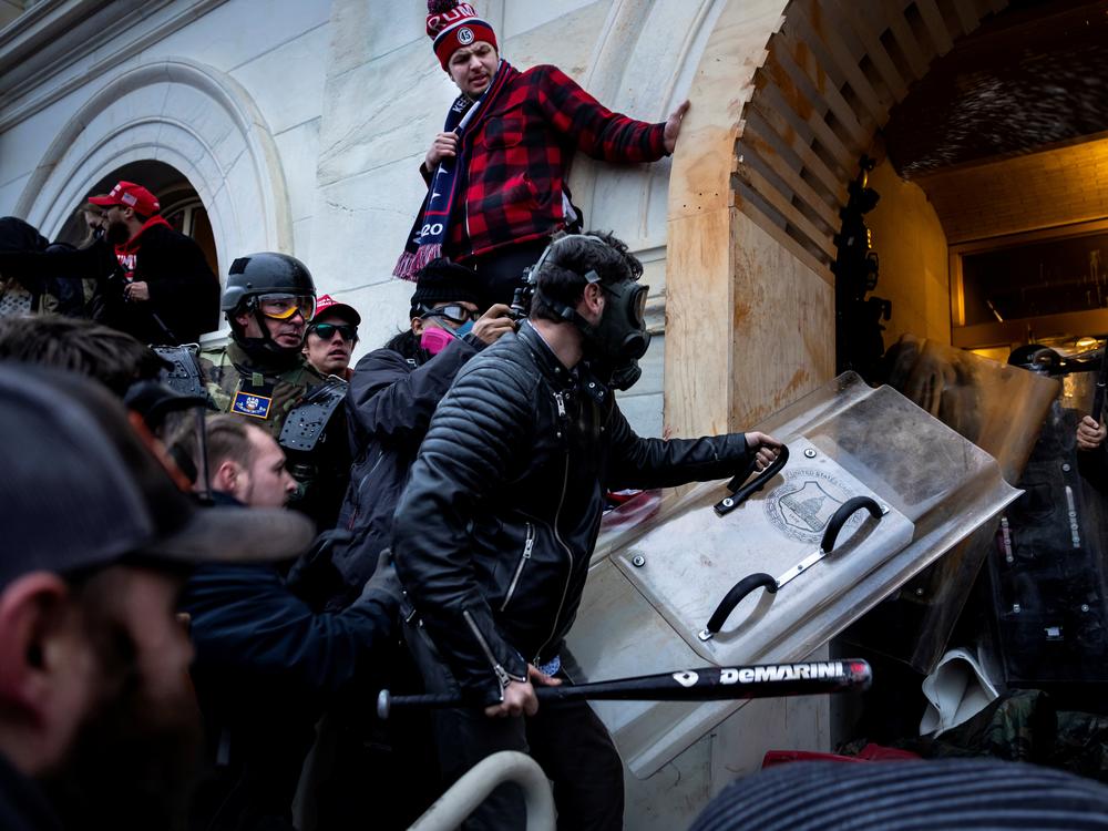 Jake Lang, center, and other Trump supporters clash with police and security forces on January 6, 2021 in Washington, DC.  Lang is one of many rioters who hope for a pardon under a new Trump administration.