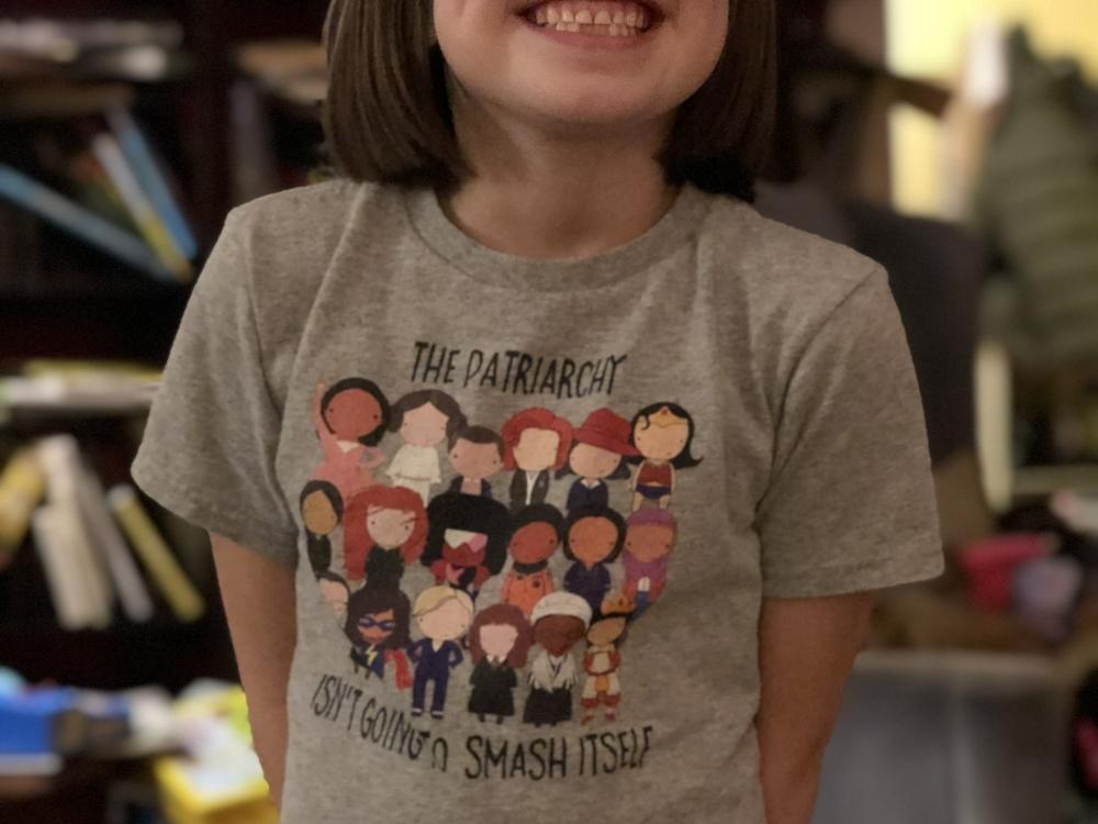 Bee, pictured when she was younger, wears a T-shirt covered in cartoon female heroes like Wonder Woman that she says now feels outdated. 