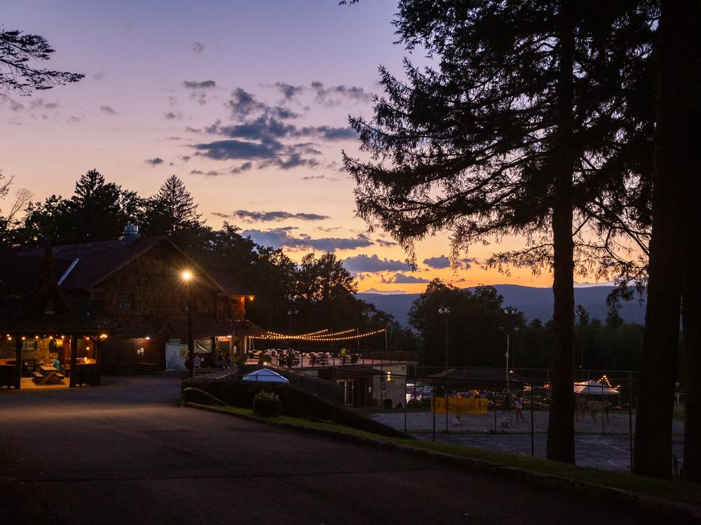 While most of the crowds are eating dinner and getting ready for the night’s festivities, security guards enjoy the quiet sunset while one final volleyball match concludes.