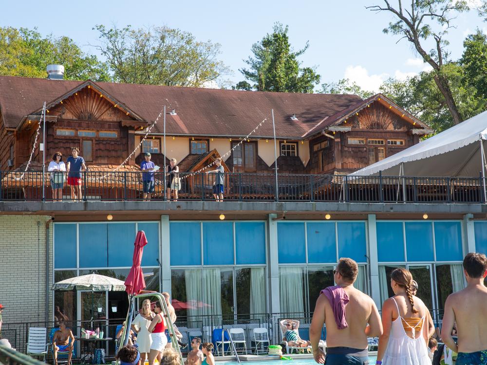 Guests look out from a newly renovated deck out toward the mountains and friends and family enjoying the pool.