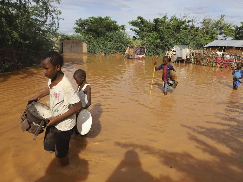 Children flee floodwaters that wreaked havoc in Kenya in April. The impact of the calamitous rains that struck East Africa from March to May was intensified by a mix of climate change and rapid growth of urban areas, an international team of climate scientists said in a study.