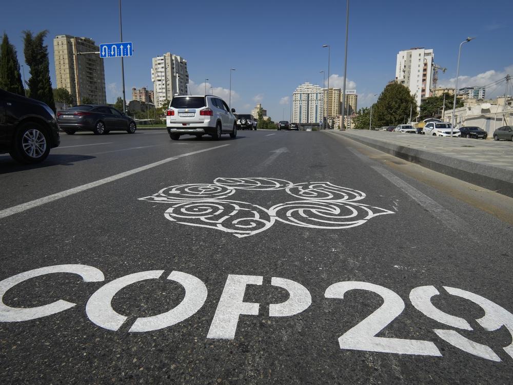 The logo for the COP29 climate change conference is painted on a road in Baku, Azerbaijan.