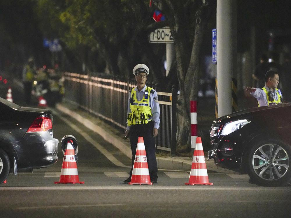 A security person stands guard near a sports center where a man rammed a car into people exercising in Zhuhai, China, on Monday.