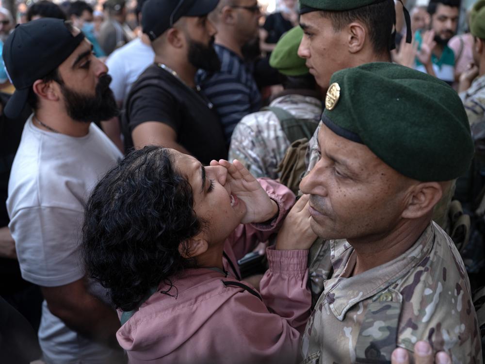 A displaced woman protests as Lebanese army soldiers attempt to evict displaced people from an old hotel in the Hamra district, in Beirut, Lebanon, on Oct. 21.