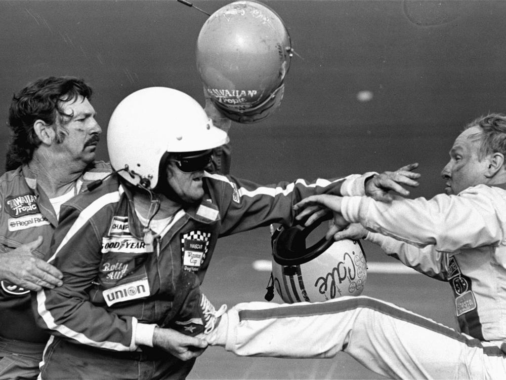Bobby Allison, center, holds race driver Cale Yarborough's foot after Yarborough, right, kicked him following  the Daytona 500 auto race in Daytona Beach, Fla., Feb. 18, 1979.