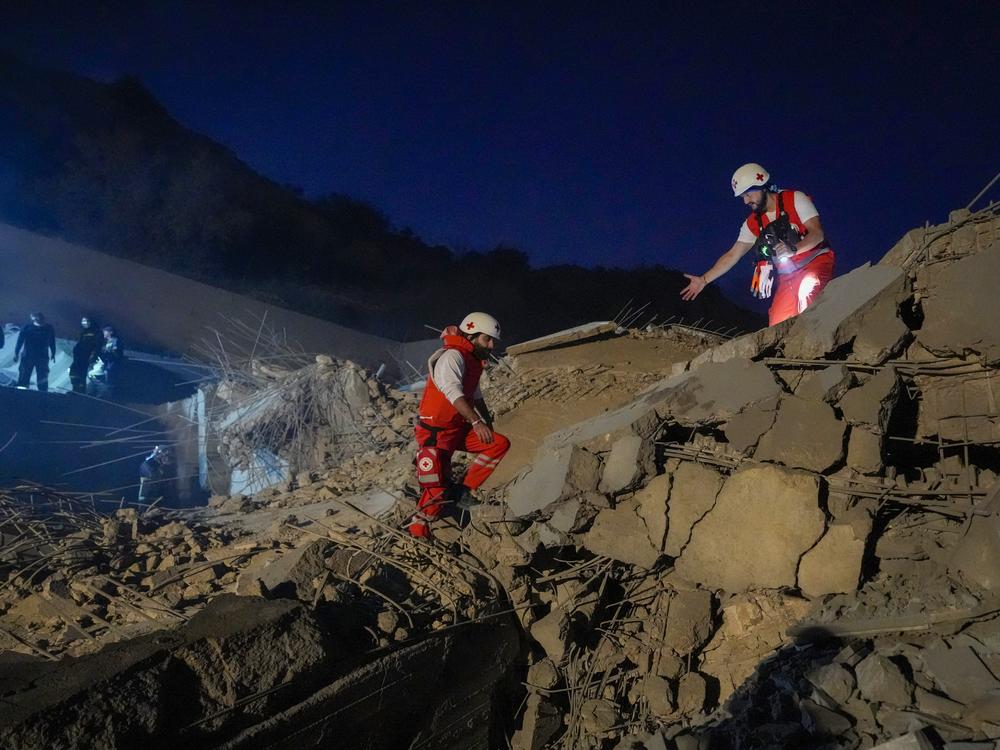 Lebanese Red Cross volunteers and other rescuers search for victims at a house that was hit in an Israeli airstrike in Baalchmay village east of Beirut, Lebanon, Tuesday, Nov. 12, 2024.