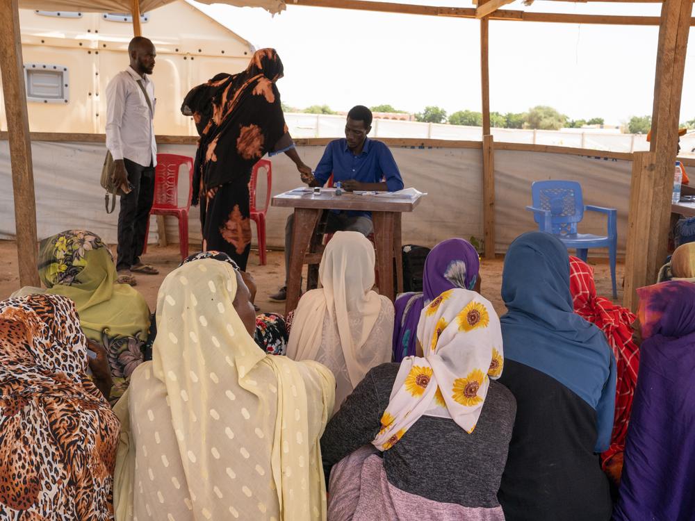 Women collect hygiene kits from a distribution by the charity World Vision at the Adre refugee camp. The items include soap, buckets, blankets and curtains. In distributing the kits, the organization gives priority to women who have experienced sexual violence.