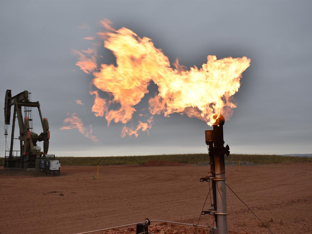 A flare burns natural gas at an oil well in Watford City, N.D. in 2021. Oil and natural gas companies would have to pay a fee for methane emissions that exceed certain levels under a new rule announced by the Environmental Protection Agency Tuesday.