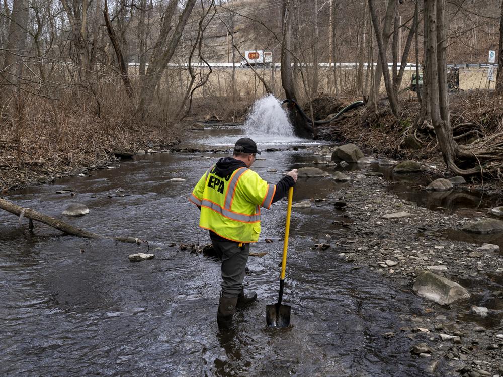 Ron Fodo, a member of the Ohio EPA Emergency Response team, checks for chemicals that have settled at the bottom of a creek following a train derailment in East Palestine, Ohio in February 2023.