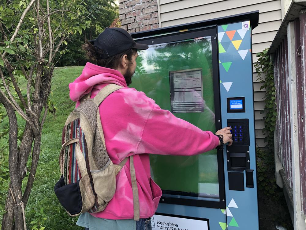 Brian taps in the code to dispense fentanyl test strips from the new harm reduction vending machine in North Adams, MA.  Anyone can get the test strips for free. But to receive drug-use supplies like needles and pipes, clients of the nearby clinic must register for an access code. The machine is cooled and heated to preserve medications like Narcan.