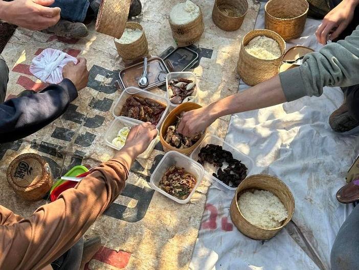 Near Israel's border with Lebanon, Ubon Namsan and fellow laborers enjoy a traditional meal from their native Thailand.
