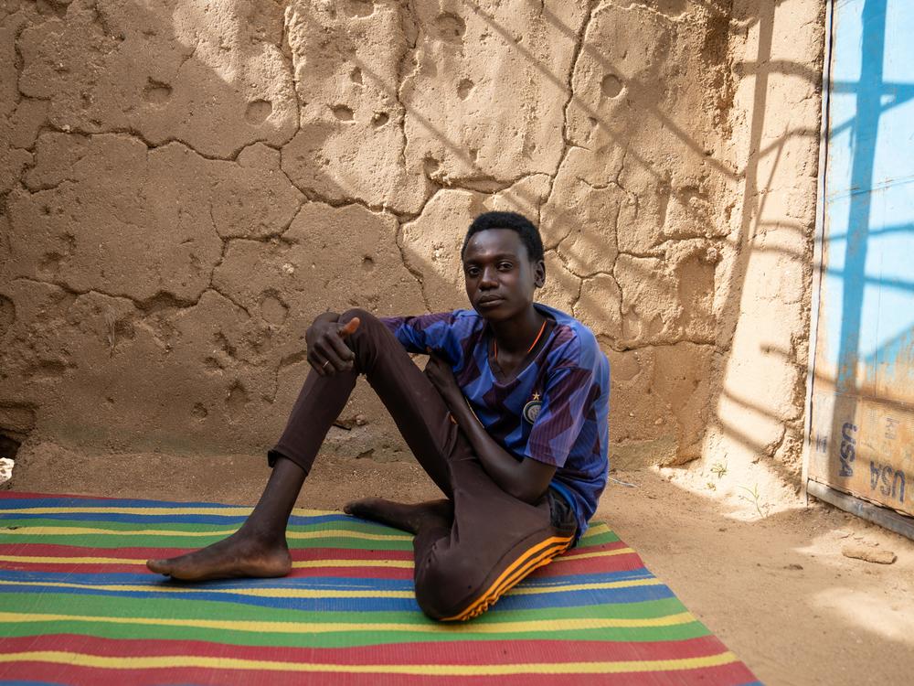 <strong>Mahamat Djouma, 14, arrived in Chad from Sudan without his parents -- and with his 5-year-old twin brothers, whom he now cares for. He is photographed outside the one-room mud brick home where they live. There's no roof, just a plastic tarp that leaks when it rains.</strong>