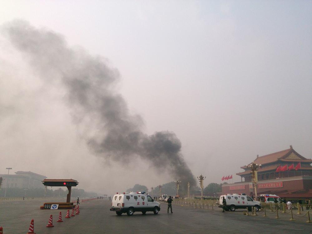 Police cars block off the roads leading into Tiananmen Square as smoke rises after a vehicle crashed in front of Tiananmen Gate in Beijing, on Oct. 28, 2013, killing several people.